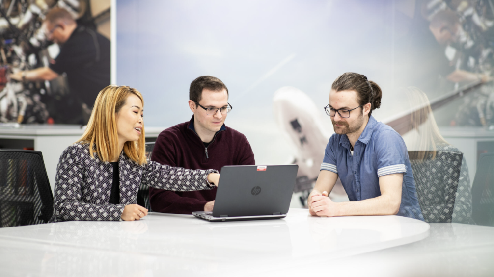 Three members of the BAE Systems cyber security team have a meeting around a table