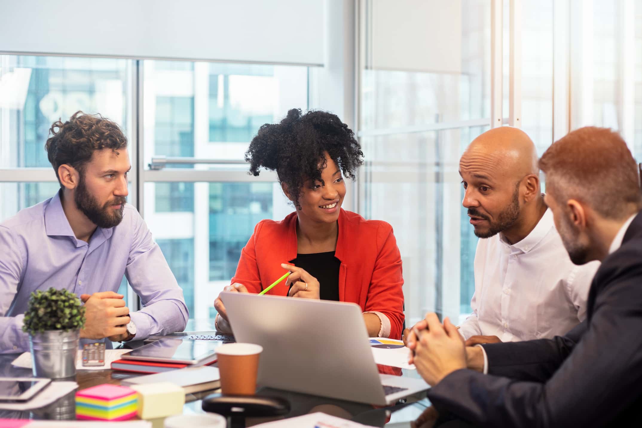 Employees chatting around a table in a well-lit office