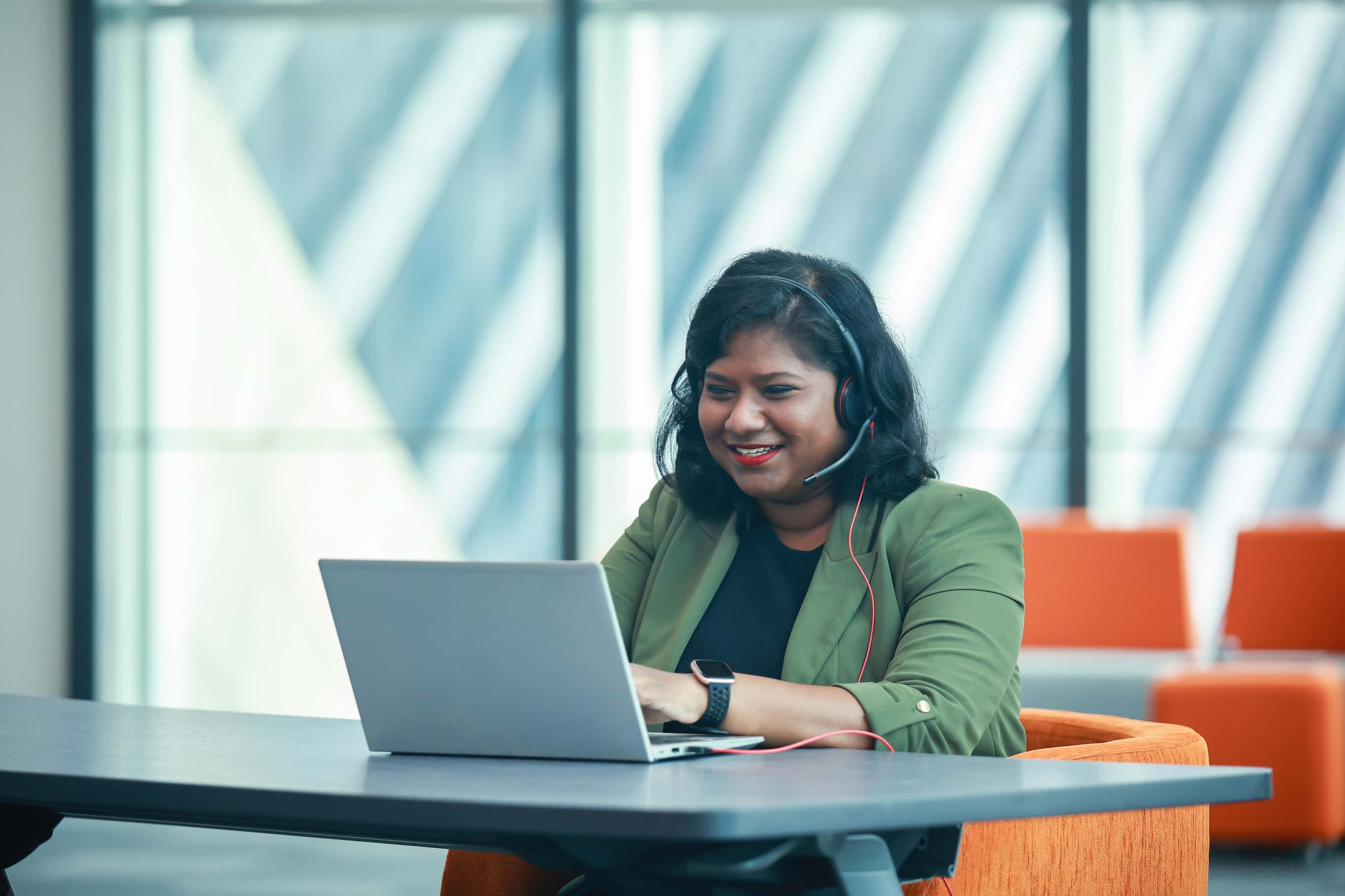 Employee on a remote call from her laptop in a well-lit office space