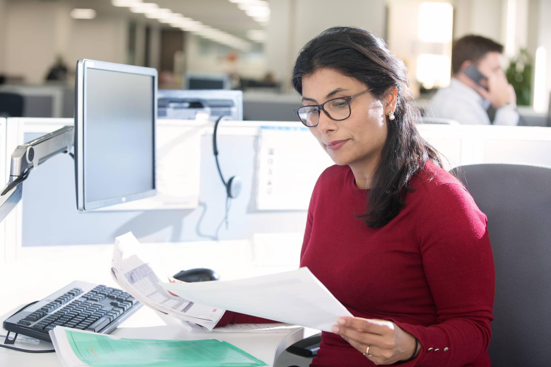 Employee examining documents at computer