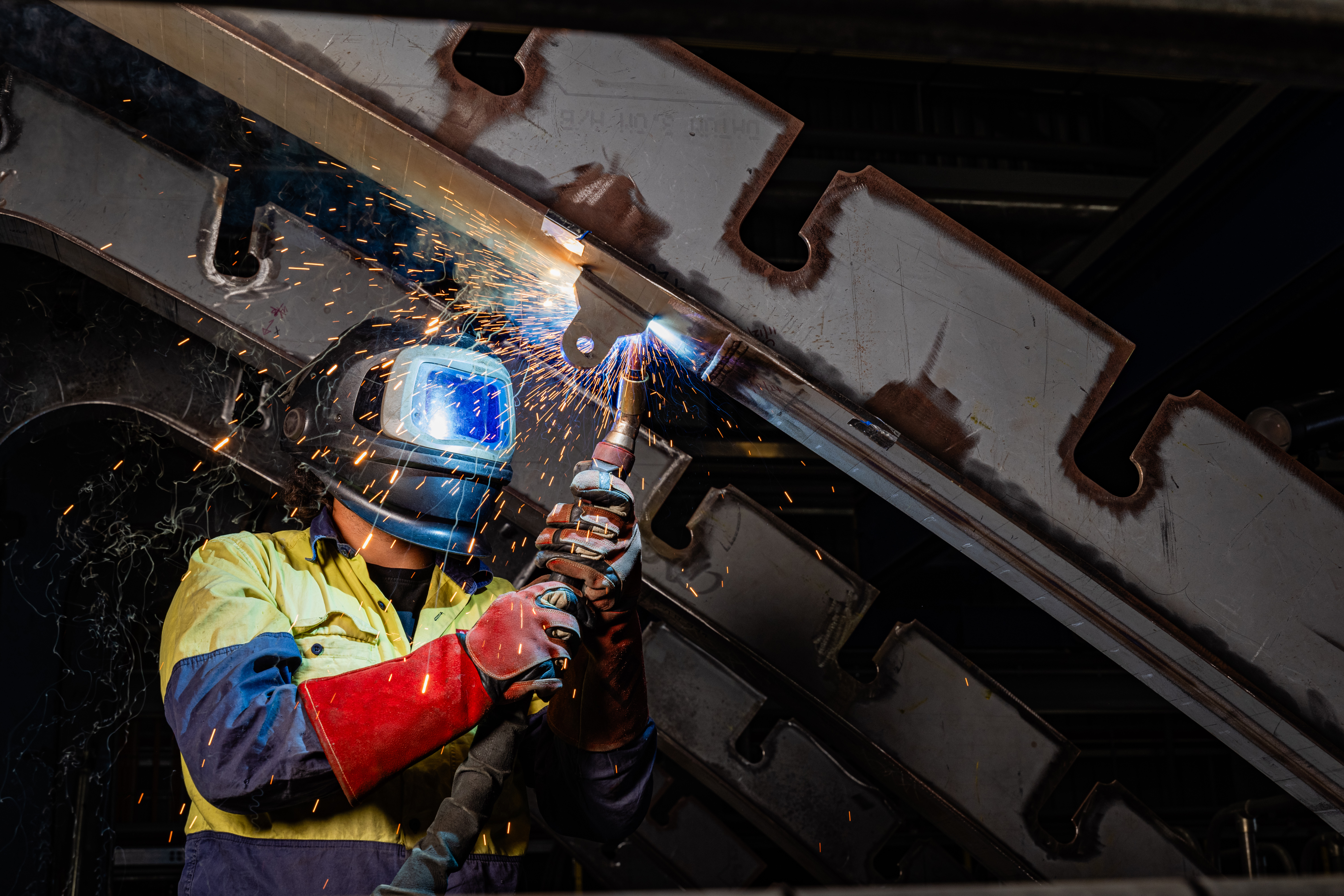 Welder protected from sparks by mask