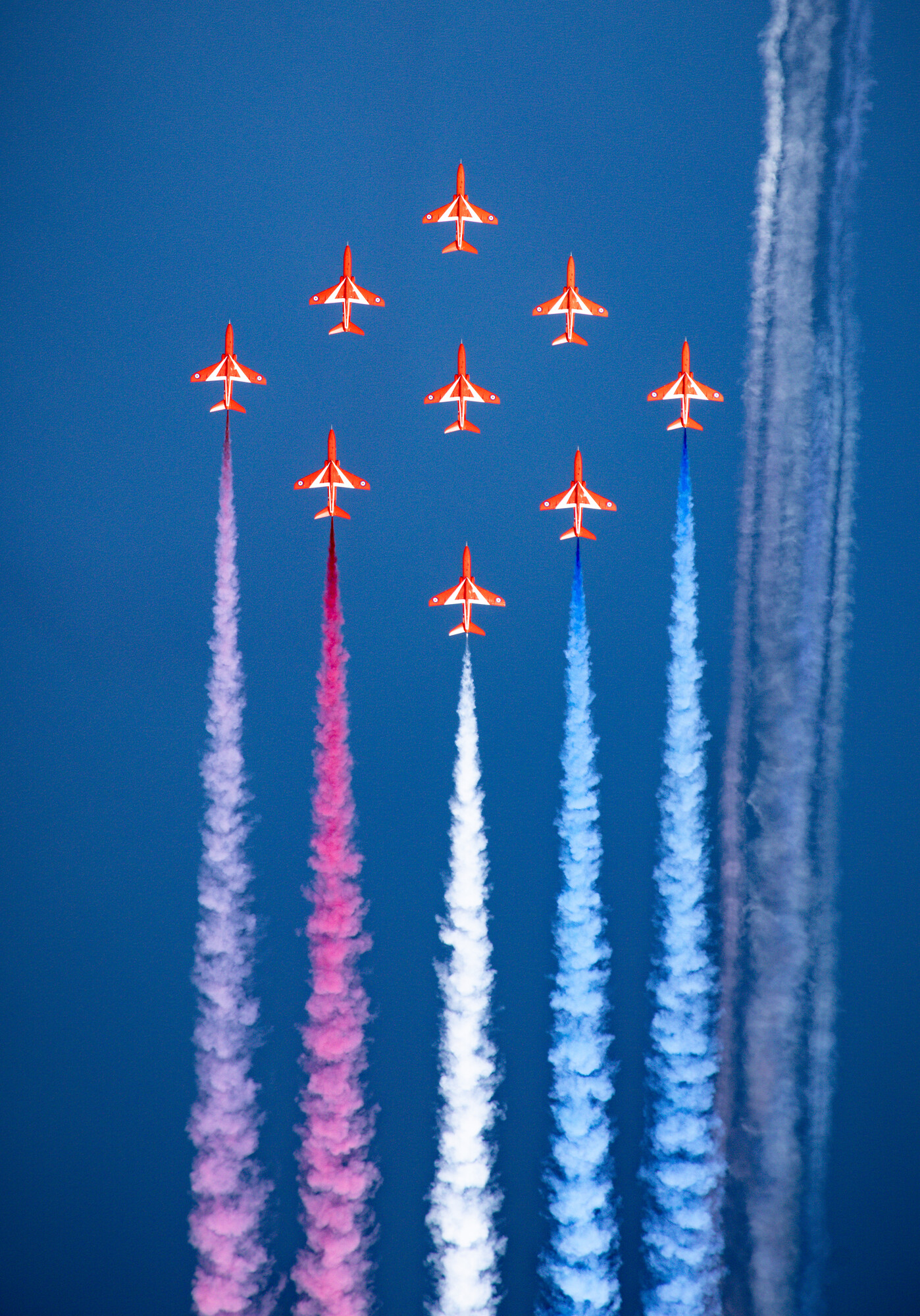 Crown Copyright - The Red Arrows Diamond 9 formation flying with a smoke trail off the aircrafts in the colour of the Union Jack flag: red, white and blue. 